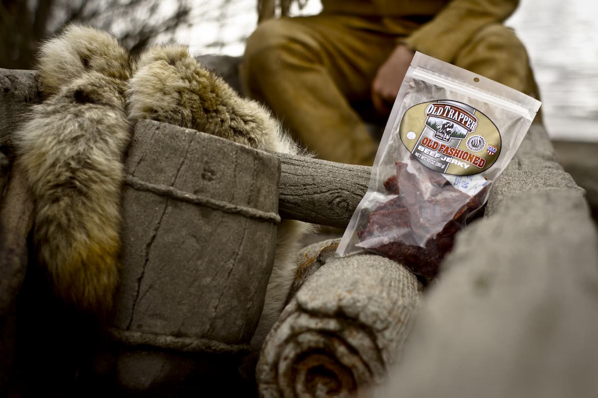 Old Trapper beef jerky is displayed next to a camping ground.