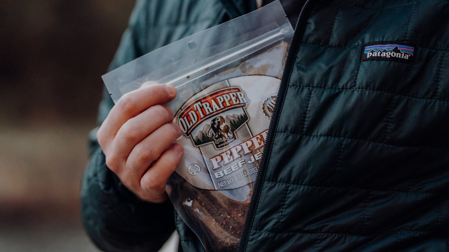 A packet of Old Trapper Beef Jerky fits snugly in a person's jacket